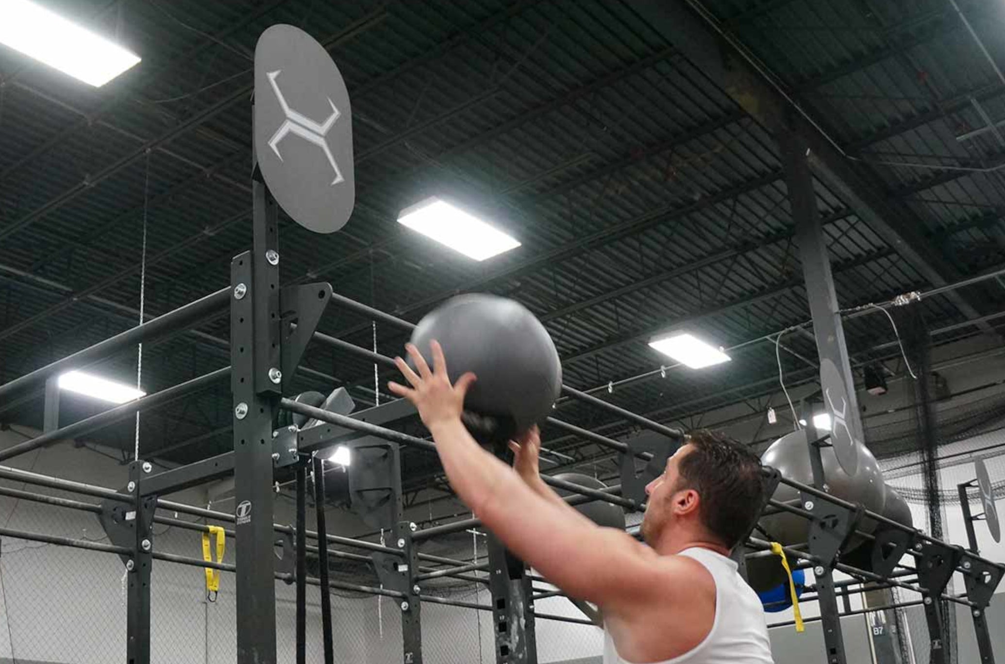 Man Throwing Wall Ball On Ball Target Attached To Rack